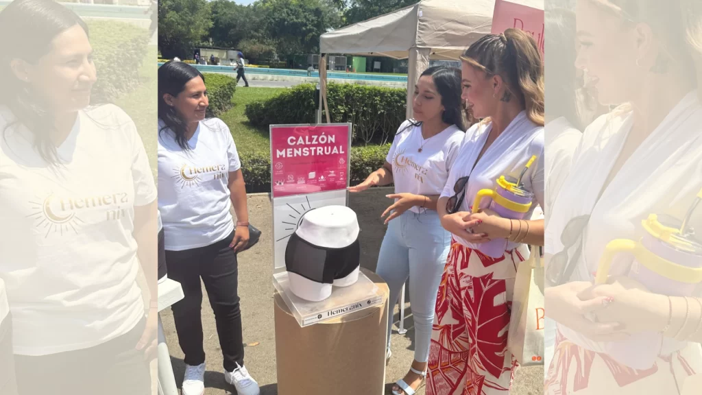 Ducelia Echevarría escucha atenta la explicación del calzón menstrual Hemeranix en un evento social de la Liga Contra el Cáncer